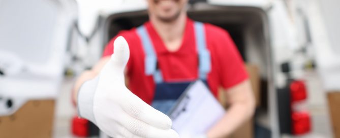 White glove delivery concept: Delivery man holding out hand wearing a white glove to give a handshake.